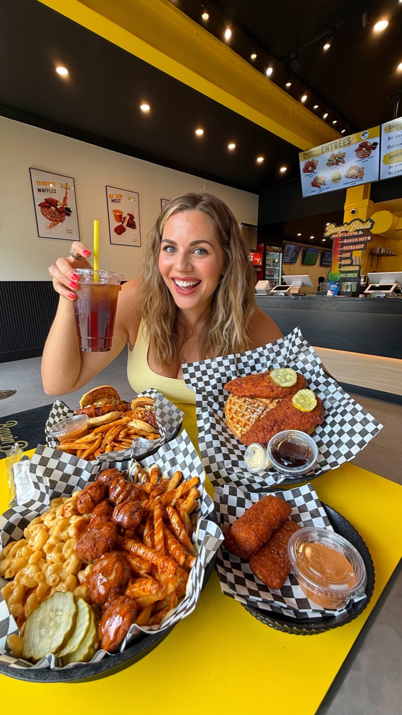 Carla with a spread of hot chicken, waffles, mac and cheese and fries