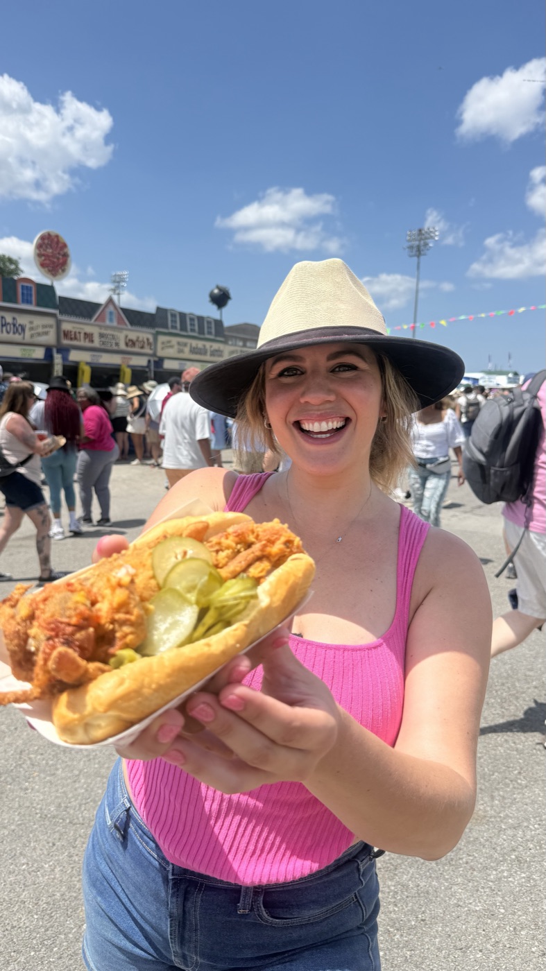 Carla holding a fried po-boy at Jazz Fest at the Fair Grounds