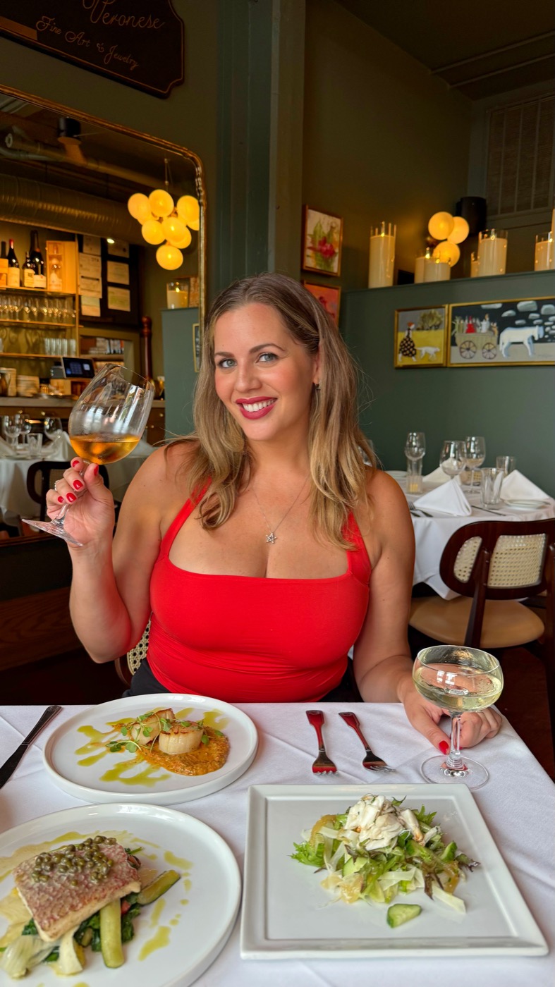 Carla raising a glass of white wine